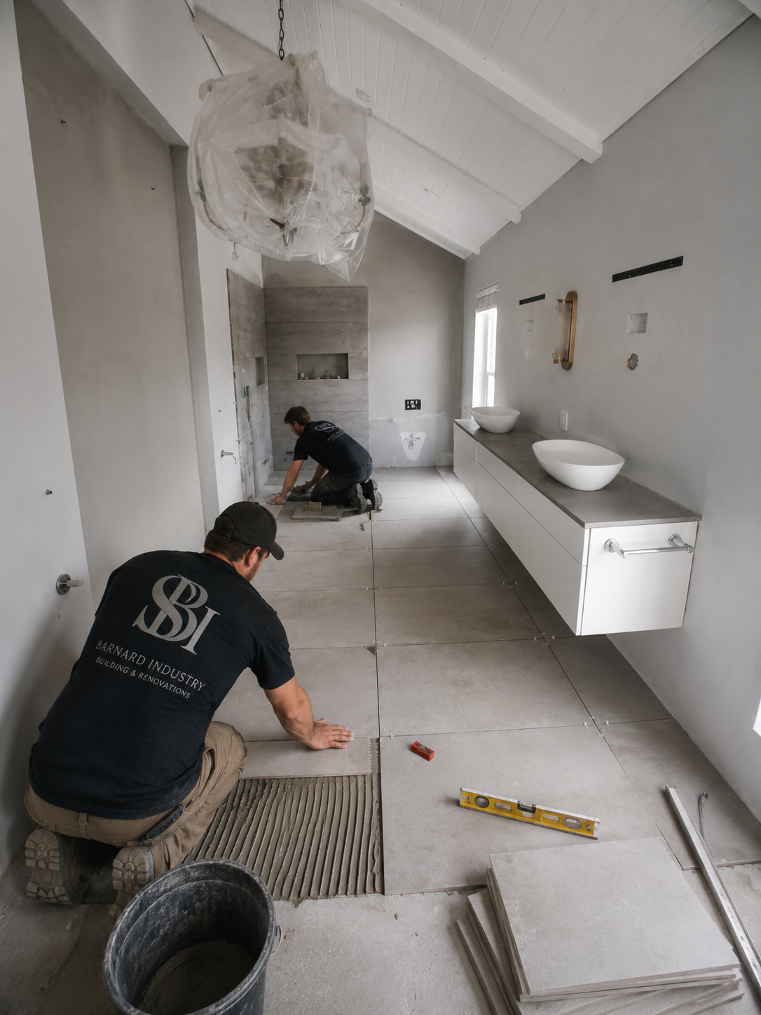 Barnard Industry team tiling a luxury bathroom renovation with twin stone basins